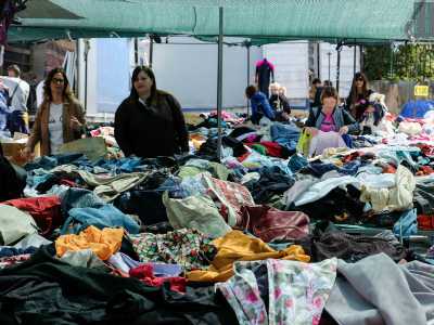 Sui banconi di legno, buttati alla rinfusa, ci sono magliette, jeans, giacche, camicie, sciarpe, persino divise militari che aspettano un nuovo padrone